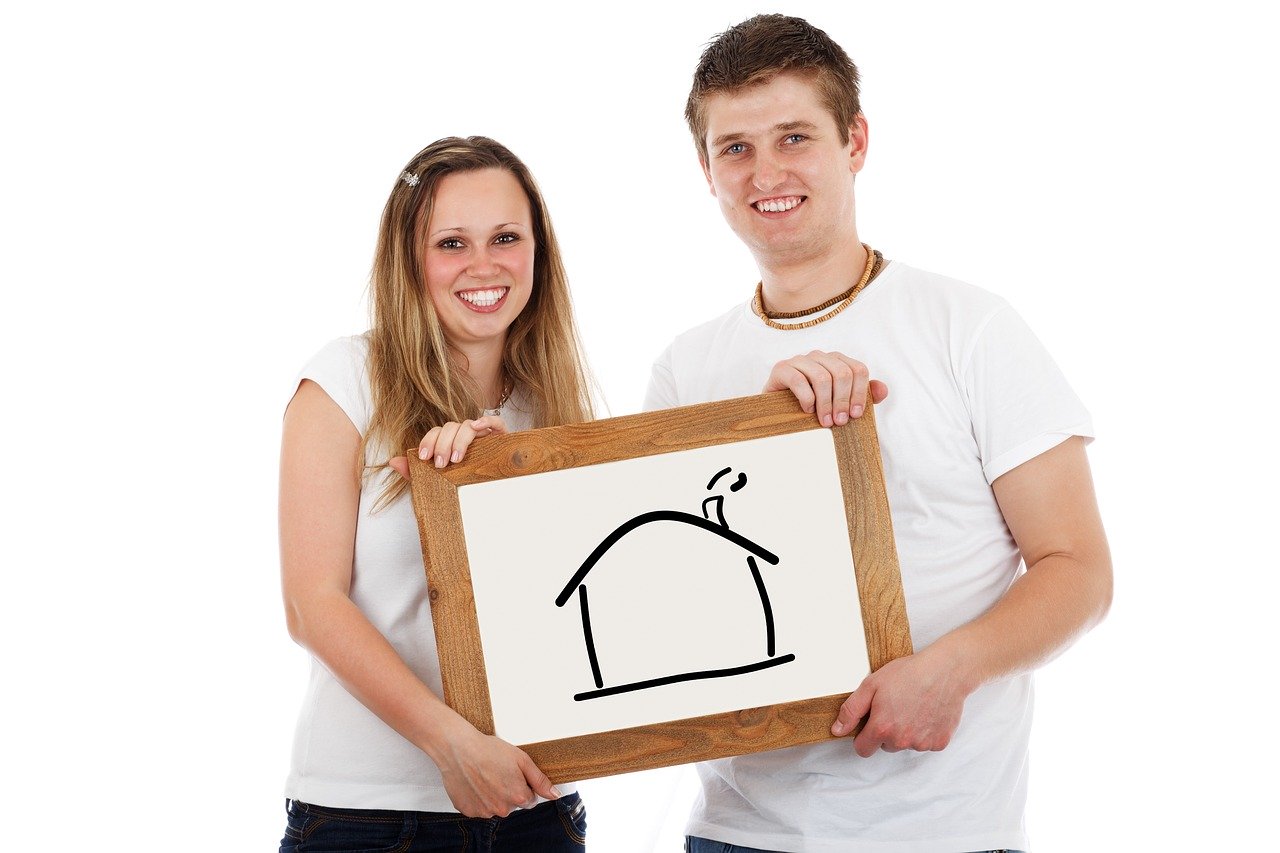 image of couple holding a picture of a house